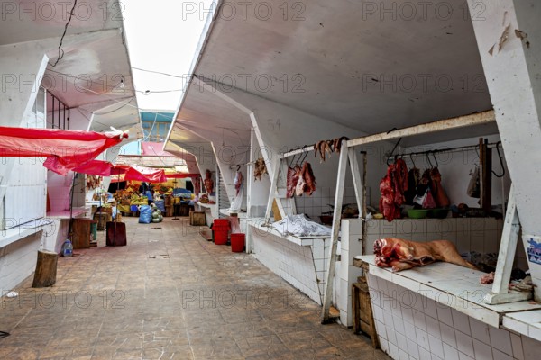 Covered market area with various stalls and an aisle in the centre, The meat market in the market halls of Potosi in Bolivia