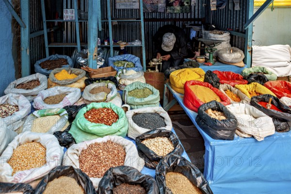 Colourful spices and grains in sacks on a market stall, variety and aromas create a lively atmosphere, market stall selling spices and food in the market halls of Potosi Bolivia