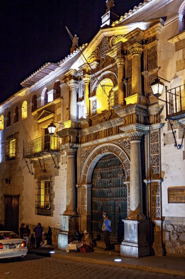 Illuminated historical building at night with people nearby, The churches of the city of Potosi in Bolivia
