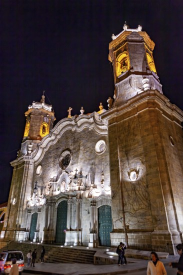 Illuminated church at night with decorative lighting effects and passers-by, The churches of the city of Potosi in Bolivia