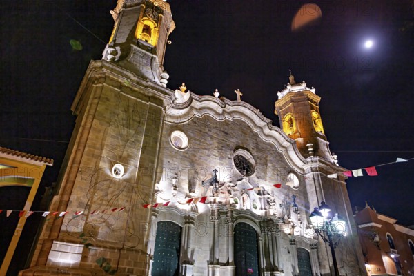 Illuminated church under the night sky with festive lights and flags, The churches of the city of Potosi in Bolivia