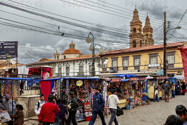 Lively town square with market stalls in front of a baroque church and under a cloudy sky, Small market stalls in the centre of Potosi in Bolivia