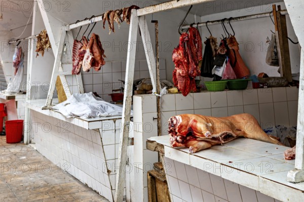 A rustic market stall with raw meat hanging on tiled walls, The meat market in the market halls of Potosi in Bolivia
