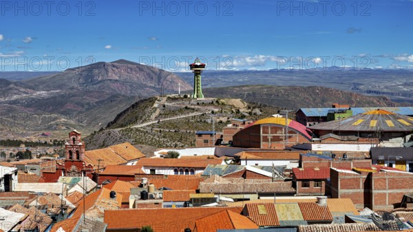 View of orange roofs with a modern building and an antenna in a mountainous environment, view over the city of Potosi in Bolivia