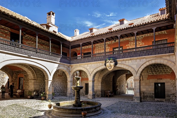 A historic courtyard with a central fountain, surrounded by colonial architecture and stone walls under a blue sky, The courtyard of the museum of the city of Potosi in Bolivia