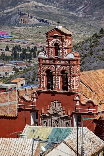 Red building with a detailed bell tower in front of a mountainous landscape, The churches of the city of Potosi in Bolivia