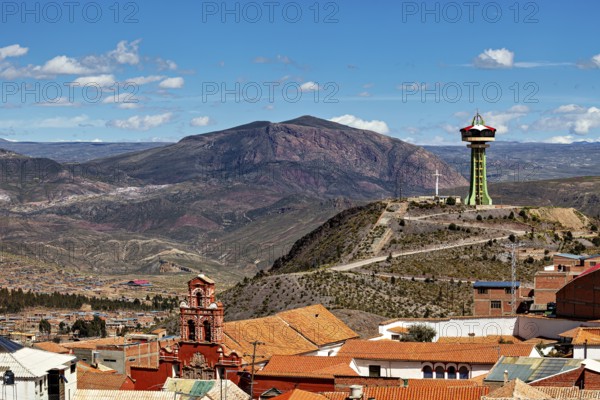 City with red roofs and observation tower, surrounded by mountains under a blue sky, The water tower of the city of Potosi in Bolivia