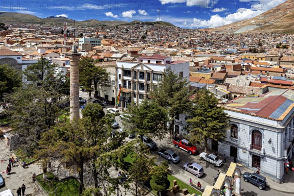 Cityscape with historic buildings and green vegetation under a sunny sky, view over the city of Potosi in Bolivia