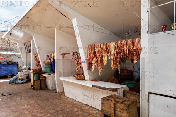 White market stall with meat hung out to dry, sunny atmosphere, rustic surroundings, The meat market in the market halls of Potosi in Bolivia