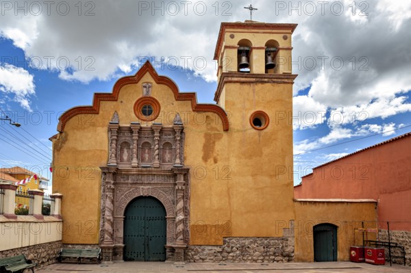 Colonial church with baroque bell tower and impressive wooden gate under a dramatic sky, The old churches of Potosi in Bolivia