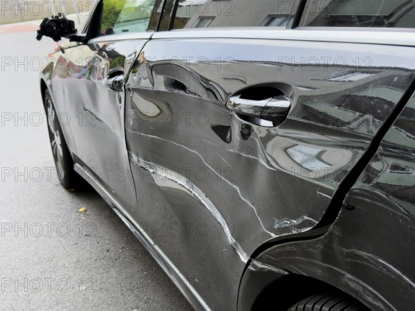 Dented car door after traffic accident, significant bodywork damage to a car in Wuppertal, Germany