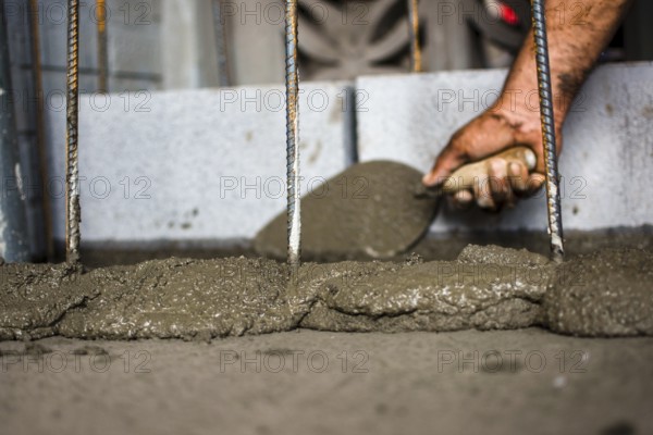 Close-up of a construction worker spreading mortar with a brick trowel
