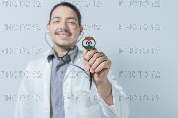 Smiling doctor showing stethoscope with India flag. India national healthcare