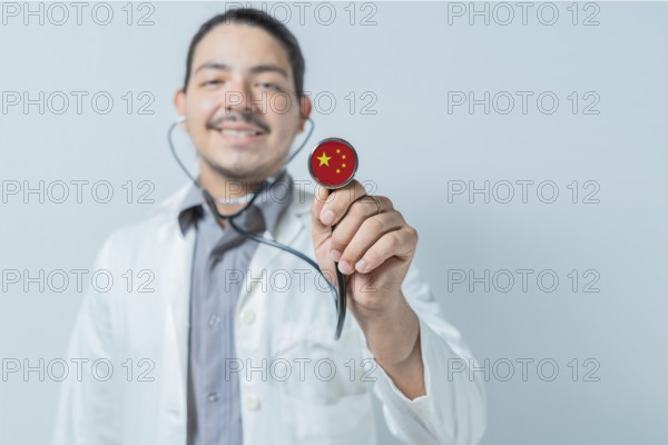 Smiling doctor showing stethoscope with China flag. China national healthcare