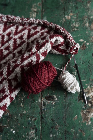 Knitted piece with ball of wool and knitting needle