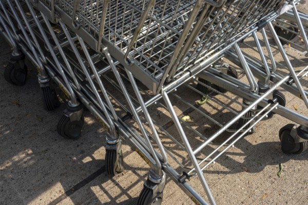 Metal shopping carts with wheels stacked together on urban concrete