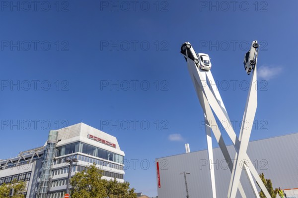 Porscheplatz with Porsche headquarters. Inspiration 911 artwork by Gerry Judah: three steles, each presenting a Porsche 911 at a height of up to 24 metres. Zuffenhausen, Stuttgart, Baden-Württemberg, Germany