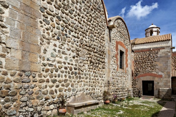 Stone walls and a church entrance under a sunny sky, surrounded by plants, The historical museum of Potosi in Bolivia