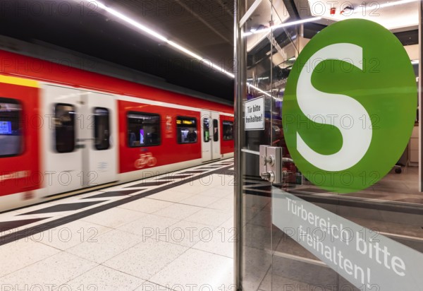 S-Bahn arriving underground at the main station stop. Platform with travellers and logo. Stuttgart, Baden-Württemberg, Germany