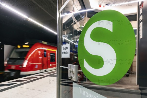 S-Bahn arriving underground at the main station stop. Platform with travellers and logo. Stuttgart, Baden-Württemberg, Germany