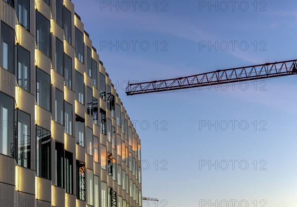 The picture shows a modern building at the main railway station in Berlin with a construction crane in the background, Germany