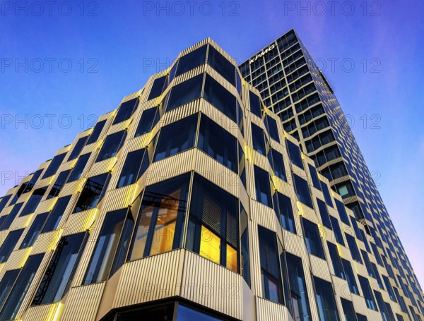 The picture shows a modern office and commercial building at the central station, warm evening light, frog perspective, Berlin, Germany