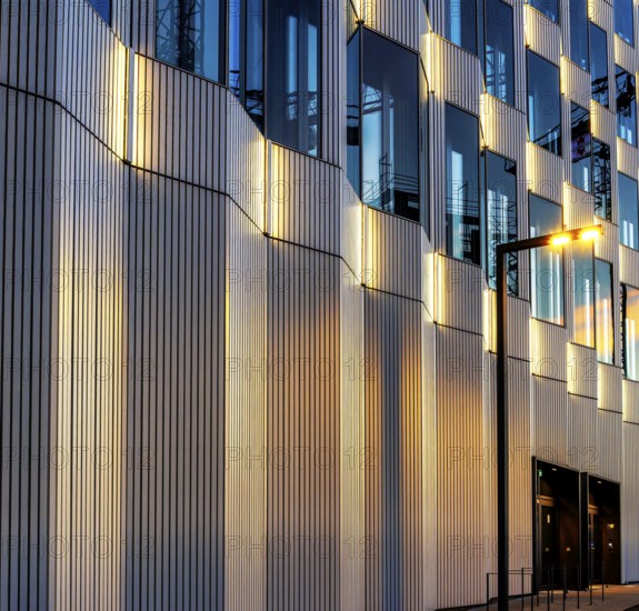 The picture shows a modern office and commercial building at the central station, warm evening light, Berlin, Germany