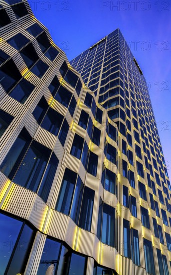 The picture shows a modern office and commercial building at the central station, warm evening light, frog perspective, Berlin, Germany