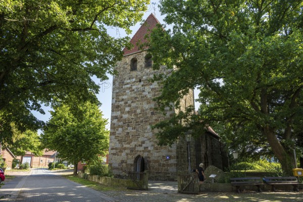 Historic stone church tower surrounded by green trees in the village, Buchholz church, Petershagen, North Rhine-Westphalia