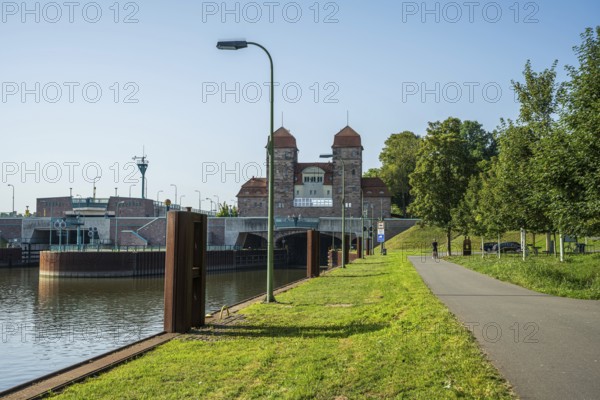 Canal with adjoining lock system and cycle path lined with trees under a blue sky, Minden waterway junction, Minden-Lübbecke, North Rhine-Westphalia