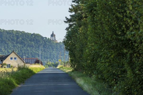 Landscape with a monument on a hill, surrounded by green trees and a house at the roadside, Kaiser-Wilhelm monument, Holzhausen, Porta-Westfalica, North Rhine-Westphalia