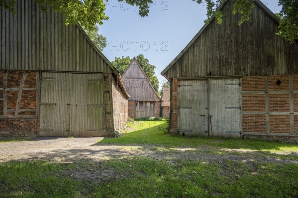 Ancient half-timbered houses with wooden and brick façades in the shade, Weser cycle path, Schlüsselburg barn quarter, Petershagen, North Rhine-Westphalia