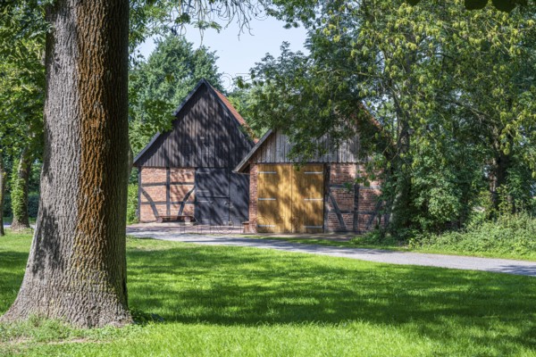Half-timbered barn with rustic charm surrounded by trees and meadows, Weser cycle path, Schlüsselburg barn quarter, Petershagen, North Rhine-Westphalia