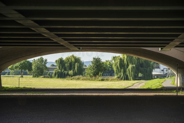 View under a bridge onto a summer landscape with willow trees, Minden waterway junction, Minden-Lübbecke, North Rhine-Westphalia