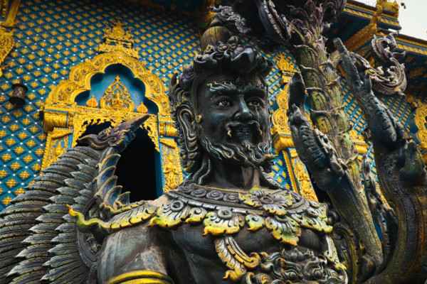 Close-up of a detailed statue with ornate gold and blue highlight in Wat Rong Suea Ten or Blue Temple. Chiang rai, Thailand