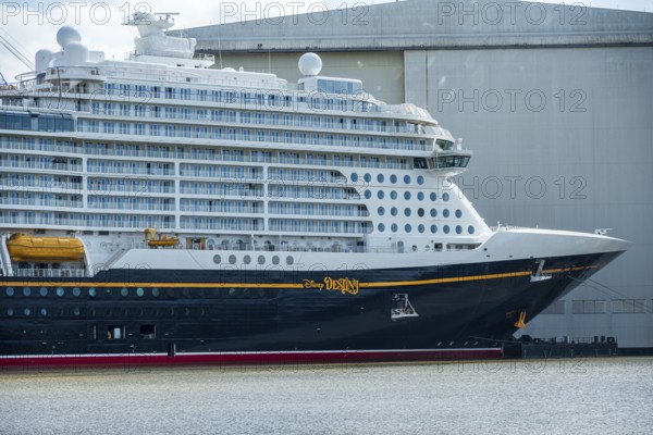 A side view of a cruise ship with distinctive lettering near a shipyard, cruise ship at the Meyer shipyard in Papenburg