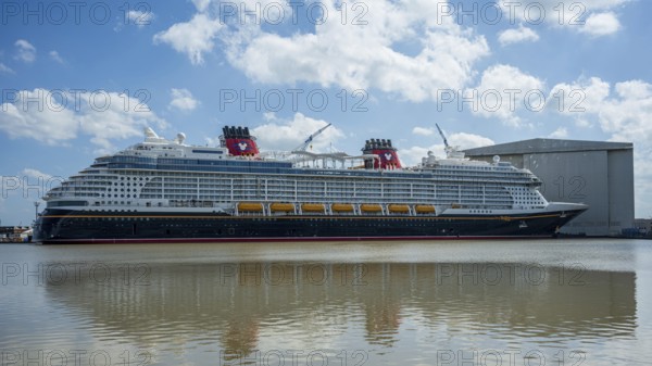 A large cruise ship moored next to a shipyard on a sunny day, cruise ship at the Meyer Werft shipyard in Papenburg