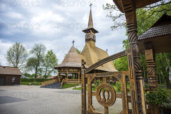 Unique wooden church with ornate carvings and horse shoes on the Tor tor, surrounded by trees, The Romanian Orthodox church near Sögel in Emsland