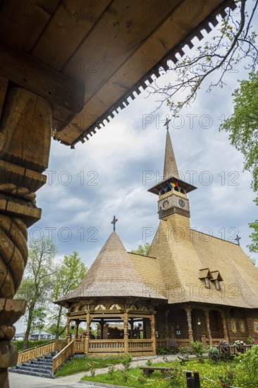 Remarkable wooden church with intricate carvings and a rustic roof against a cloudy sky, the Romanian Orthodox church near Sögel in Emsland