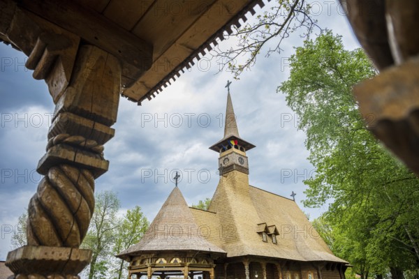 Detailed wooden church with decorative carvings and wooden roof, surrounded by trees, The Romanian Orthodox church near Sögel in Emsland
