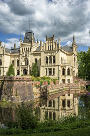 The Gothic castle with moat is picturesquely reflected in the water, Evenburg Castle, Leer, East Frisia
