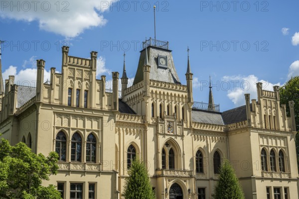 An imposing castle with Gothic elements and large windows under a blue sky, Schloss Evenburg, Leer, East Frisia