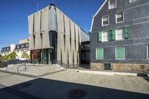 Modern glass façade next to an old house with coloured shutters, strong play of light and shadow, Museum for Early Industrialisation in Wuppertal Barmen