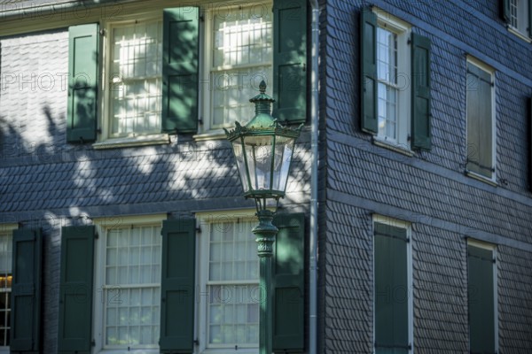 Side view of a building with green shutters, old lantern and shadow play, Friedrich Engels House in Wuppertal Barmen