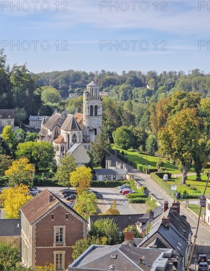 High-angle view of the charming town of Pierrefonds with view to the historic Eglise Saint-Sulpice. Vibrant autumn foliage conveying a quiet, picturesque cityscape atmosphere