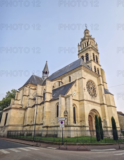 The historic Church Eglise Saint-Martin de L'Isle-Adam in France. Impressive stone architecture, tall bell tower, and prominent rose window