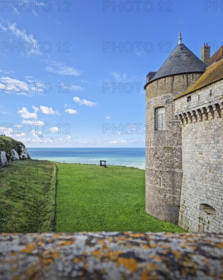 Chateau de Dieppe, a historic fortress perched on a cliff overlooking the turquoise waters of the English Channel. The castle stone walls stand proudly and lush green lawn slopes down towards the sea