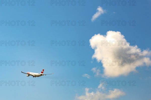 Swiss Airlines Passenger Airplane Flying Against Blue Sky and Clouds in a Sunny Summer Day From the Airport in Kloten, Zurich, Zurich Canton, Switzerland