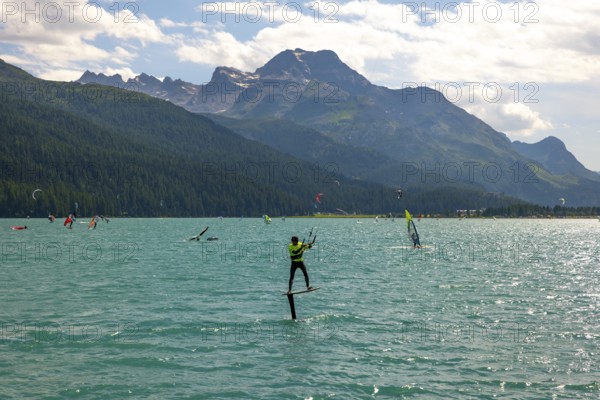 Kitesurfing on Alpine Lake Silvaplana in a Sunny Summer Day with Mountain View in the Swiss Alps in Silvaplana, Maloja, Grisons, Switzerland