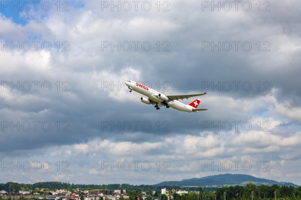Swiss Airlines Passenger Airplane Take Off From the Runway and Flying Against Blue Sky and Clouds in a Sunny Summer Day From the Airport in Kloten, Zurich, Zurich Canton, Switzerland